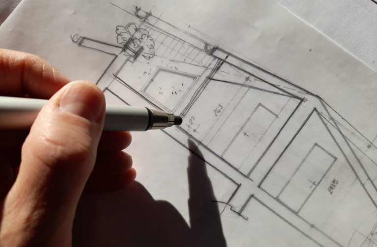 Architekturzeichnung – kreative Planung mit Präzision Hand mit Stift zeichnet einen architektonischen Entwurf auf Transparentpapier mit Linien und Maßangaben.