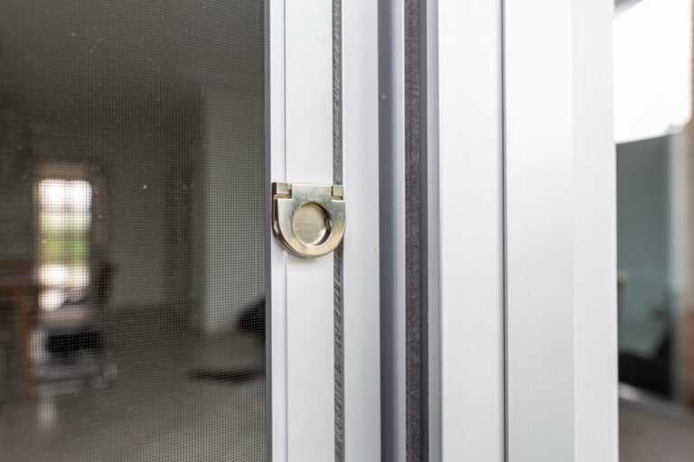 Neher 2 Detailaufnahme einer weißen Insektenschutztür aus Aluminium mit Griffschlaufe und feinem Schutzgewebe.
